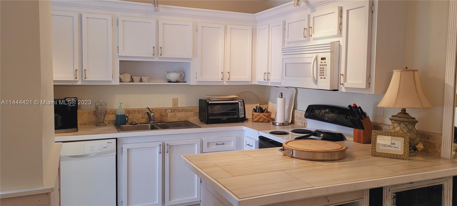 825 Center Street, Unit 28C Jupiter, FL 33458 - Photo 7 of 29 a kitchen with a sink stove and cabinets