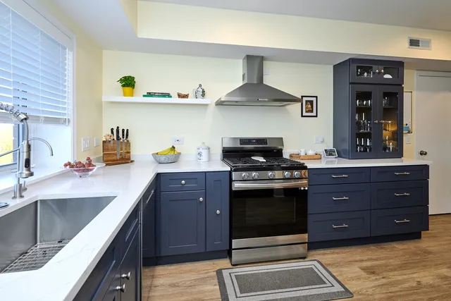 a kitchen with stainless steel appliances granite countertop a sink stove and cabinets