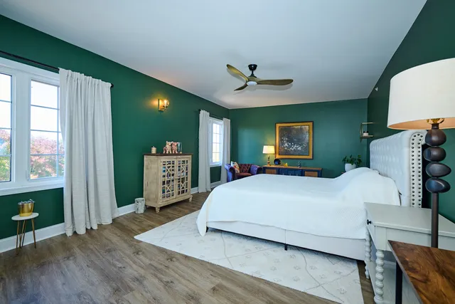 a bedroom with a large bed a chandelier and dresser