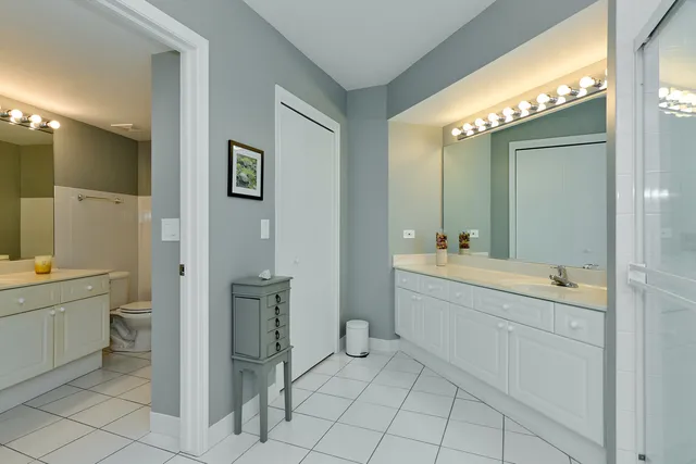 a spacious bathroom with a granite countertop sink a toilet and a mirror
