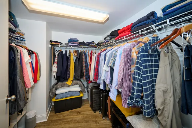 a view of walk in closet with clothes and shoes