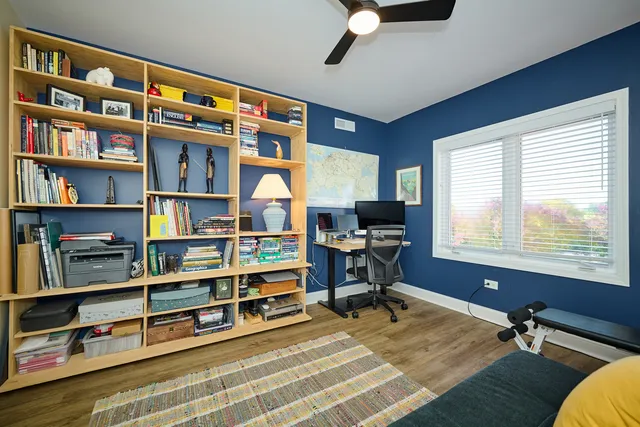 a view of a workspace with furniture and a bookshelf