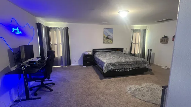a spacious bedroom with a bed and a desk