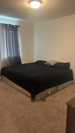 a black car sitting in a bedroom next to a window