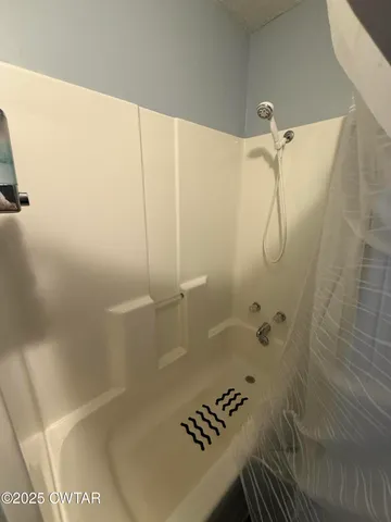 a bathroom with a bathtub and shower