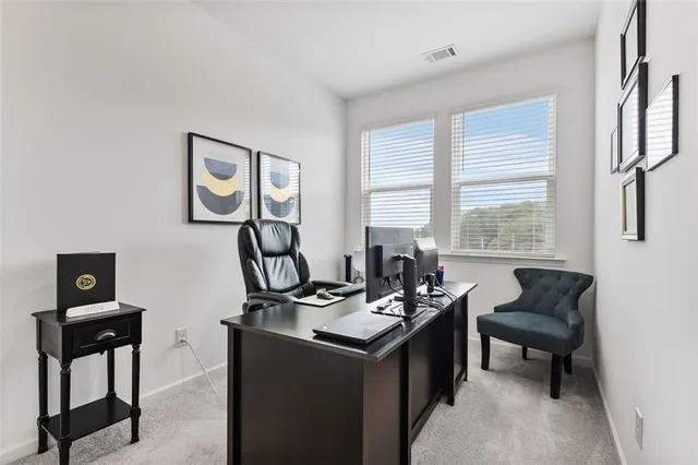 a view of a workspace with furniture and a window