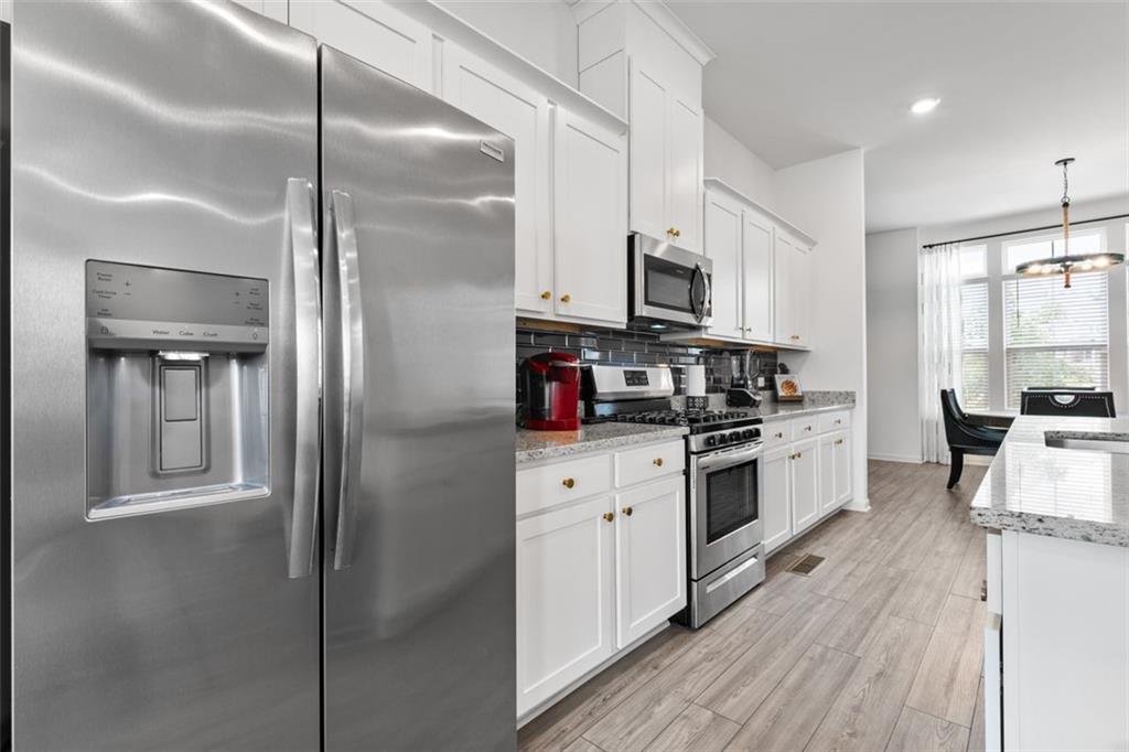 1182 Edwin Lane Sugar Hill, GA 30518 - Photo 9 of 32 a kitchen with stainless steel appliances a refrigerator sink and white cabinets