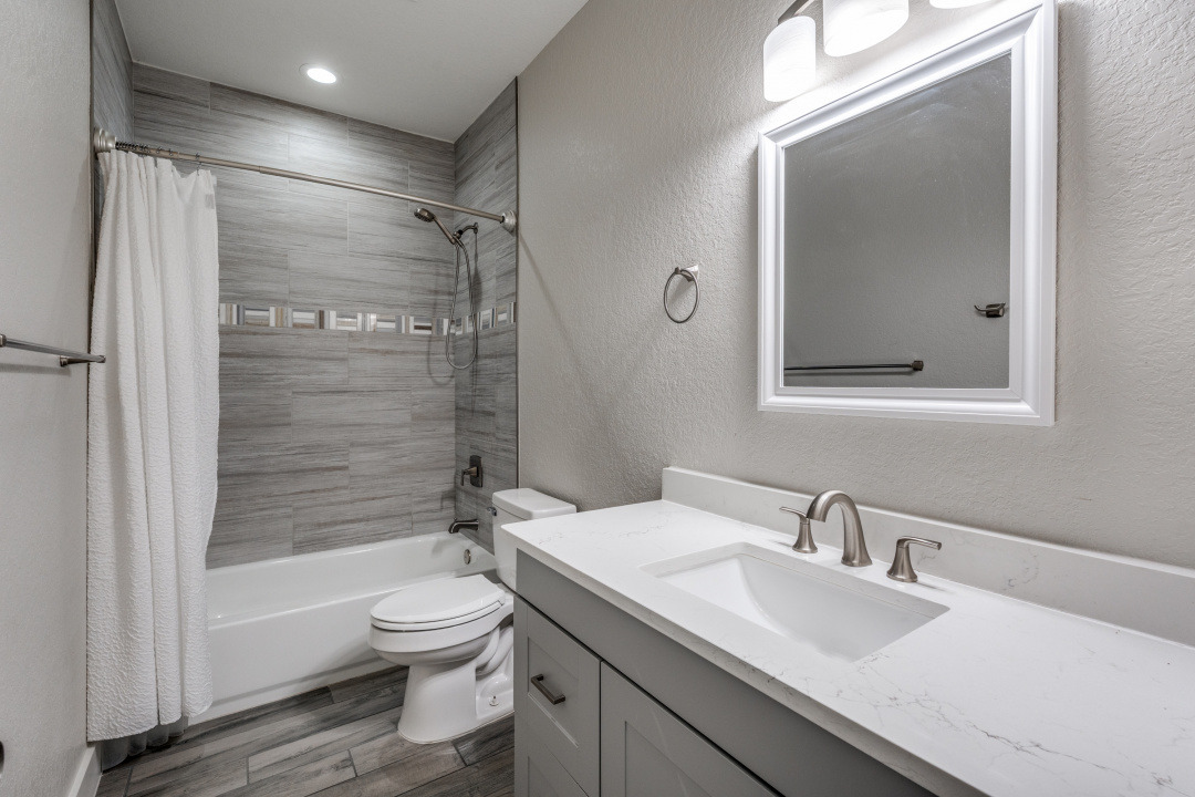 1848 Tanglewood Trail Spring Branch, TX 78070 - Photo 7 of 12 A well-appointed bathroom features a sleek vanity and a tiled shower with a decorative accent band.