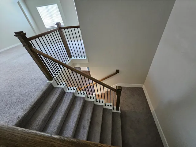 a view of staircase with wooden floor and a rug