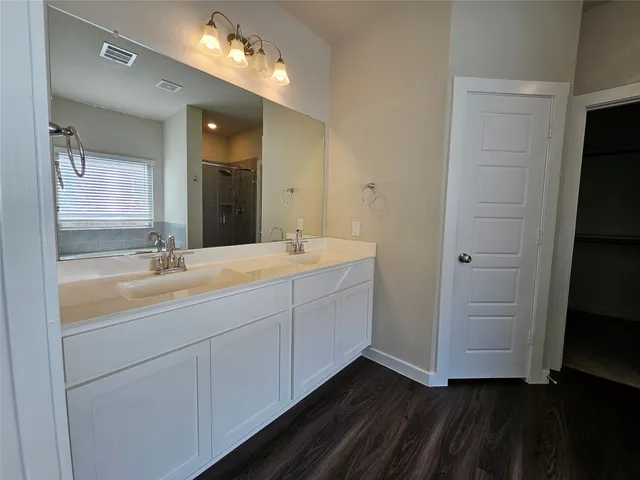 a bathroom with a double vanity sink and a mirror