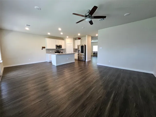 a view of kitchen with cabinets wooden floor and a sink