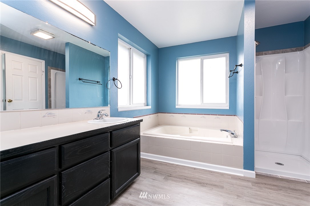 2419 East Badger Road Everson, WA 98247 - Photo 16 of 34 a spacious bathroom with a tub sink and mirror
