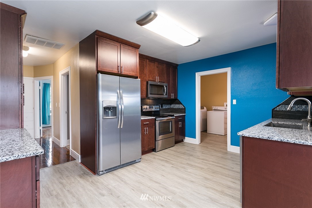 2419 East Badger Road Everson, WA 98247 - Photo 9 of 34 a kitchen with stainless steel appliances kitchen island granite countertop a refrigerator and a sink