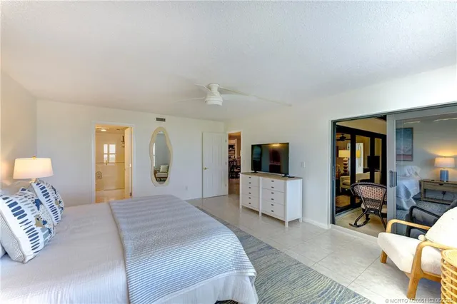 a spacious bedroom with a bed a couch and a flat screen tv