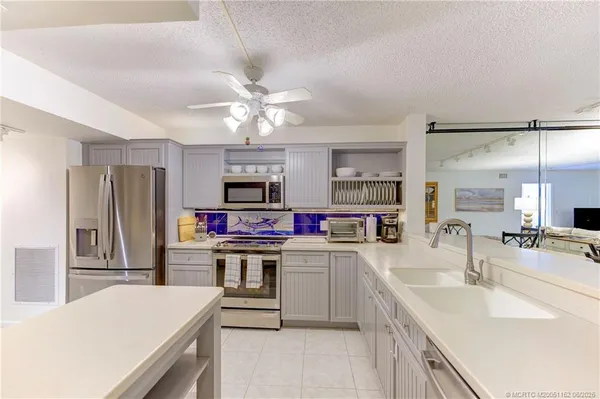 a kitchen with a sink a counter top space stainless steel appliances and cabinets
