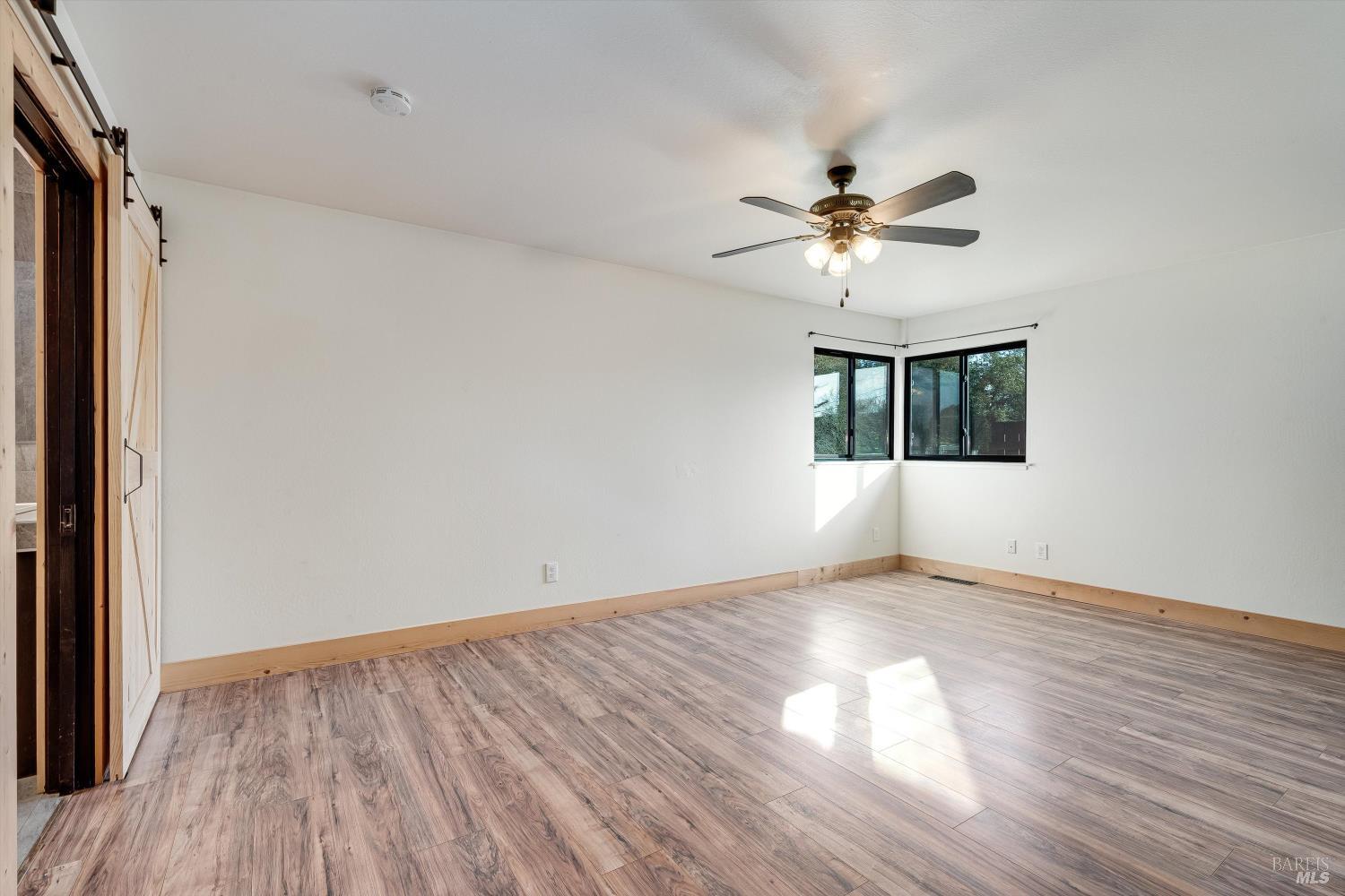 985 Gumview Road Windsor, CA 95492 - Photo 27 of 48 an empty room with wooden floor chandelier fan and windows
