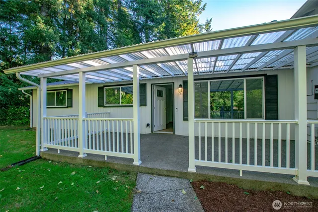 a porch with a bench next to a yard
