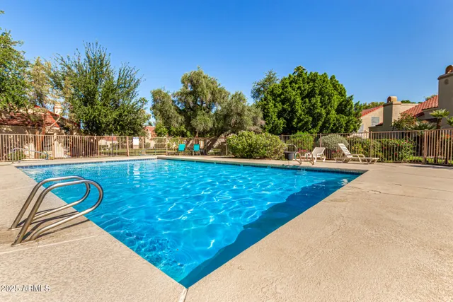 a view of a swimming pool with a patio and a yard