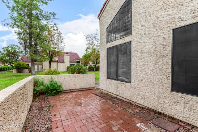 a view of a yard with brick wall and potted plants