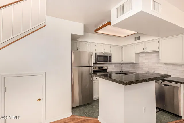 a kitchen with stainless steel appliances granite countertop a stove a refrigerator and a sink