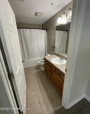 a bathroom with a granite countertop sink a toilet and a mirror