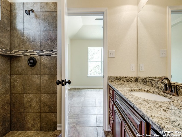 192 Weatherby Drive, Unit A Spring Branch, TX 78070 - Photo 16 of 25 a bathroom with a granite countertop sink a mirror and shower