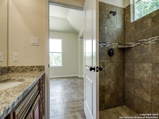 192 Weatherby Drive, Unit A Spring Branch, TX 78070 - Photo 20 of 25 a bathroom with a granite countertop shower mirror and window