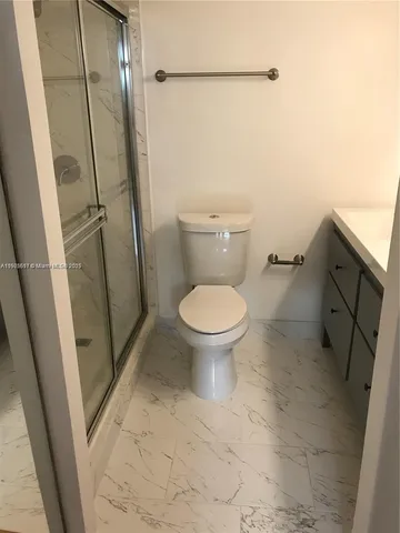 a bathroom with a toilet and a shower