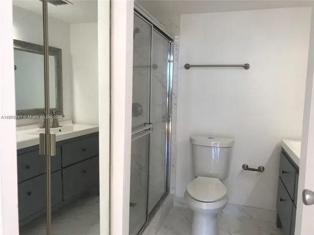 a bathroom with a granite countertop toilet sink and shower