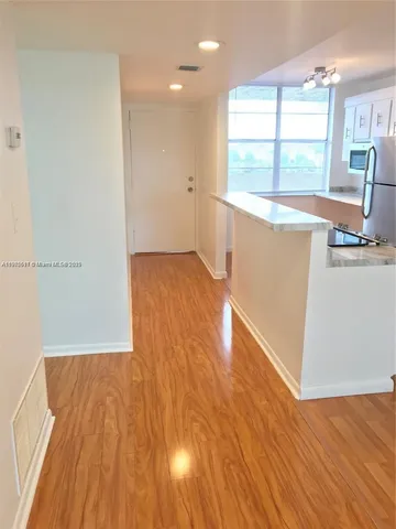 a view of a kitchen with wooden floor and a sink