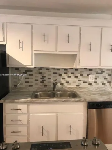 a kitchen with granite countertop a sink and a stove
