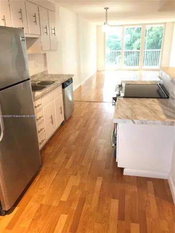a kitchen with granite countertop a stove and a white refrigerator