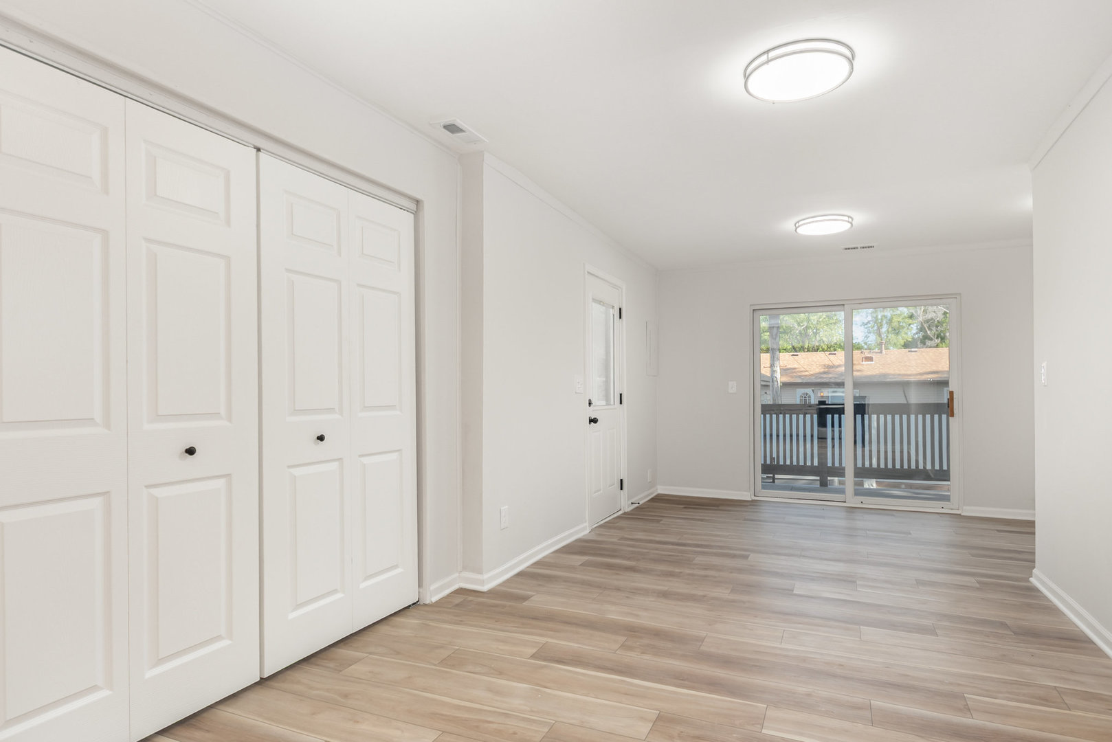 305 Luana Road Joliet, IL 60433 - Photo 8 of 16 an empty room with wooden floor and windows