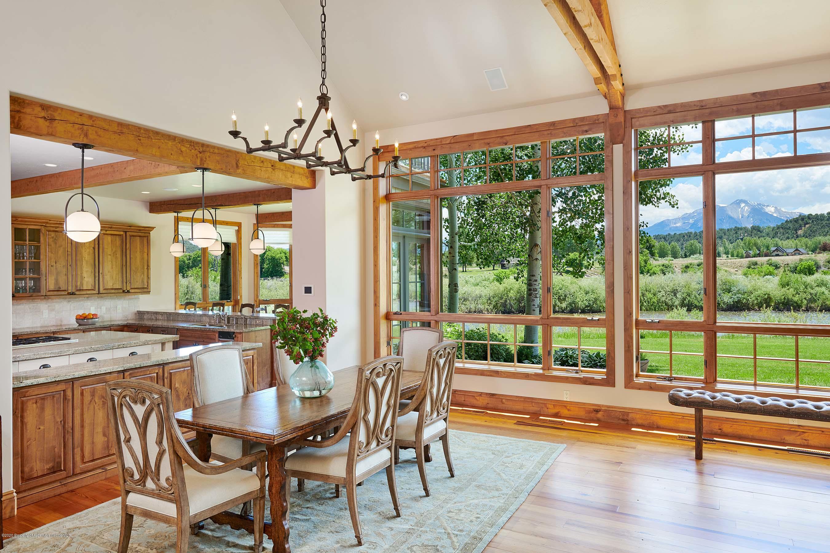 318 River's Bend Carbondale, CO 81623 - Photo 9 of 39 a dining room with wooden floor a chandelier a glass table and chairs