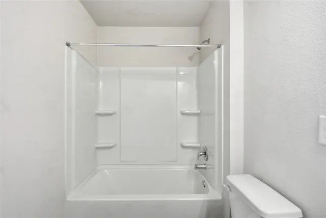 a bathroom with a bathtub and a toilet