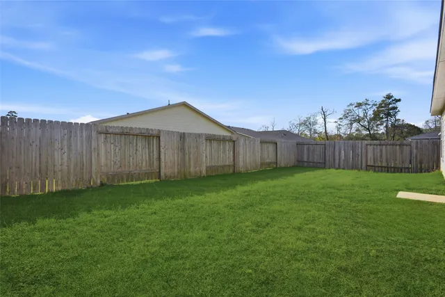 a view of a backyard with wooden fence