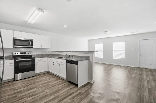 a kitchen with granite countertop a stove top oven and cabinets