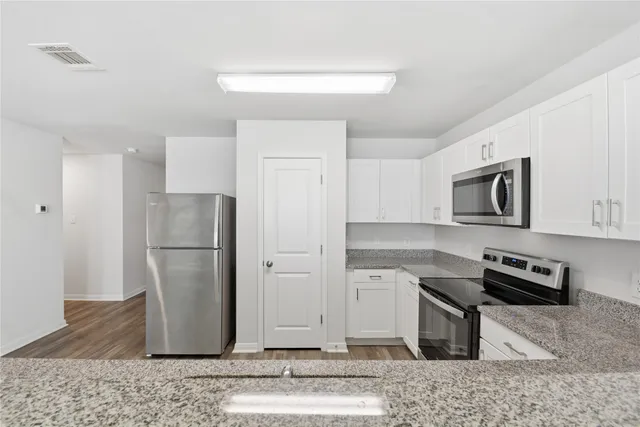 a kitchen with stainless steel appliances granite countertop a refrigerator and a sink