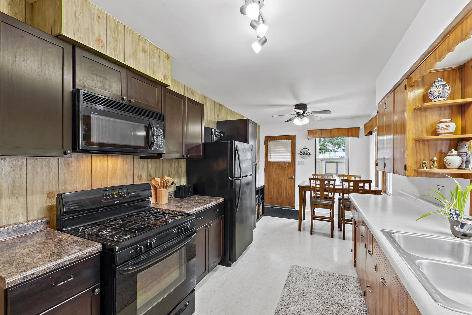 377 Cass Street Crete, IL 60417 - Photo 11 of 14 a kitchen with stainless steel appliances granite countertop a stove top oven a sink dishwasher a dining table and chairs with wooden floor