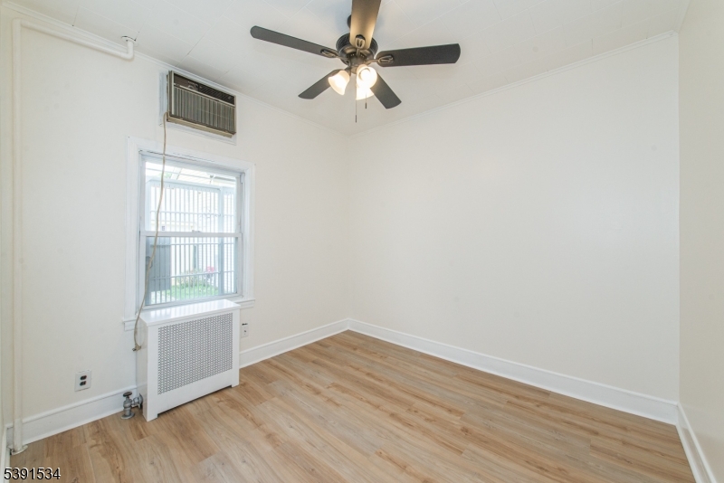 638 Clifton Avenue Clifton, NJ 07011 - Photo 15 of 21 an empty room with wooden floor fan and windows