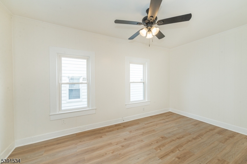 638 Clifton Avenue Clifton, NJ 07011 - Photo 16 of 21 an empty room with wooden floor fan and windows