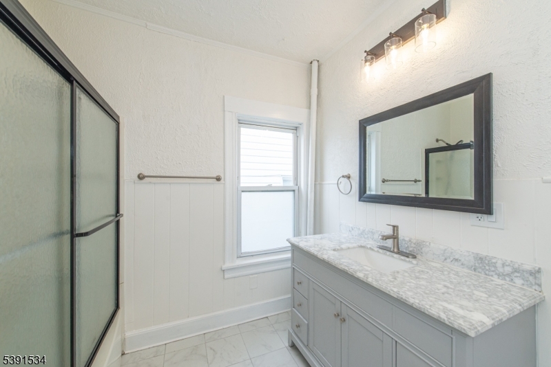 638 Clifton Avenue Clifton, NJ 07011 - Photo 18 of 21 a bathroom with a granite countertop sink and a mirror