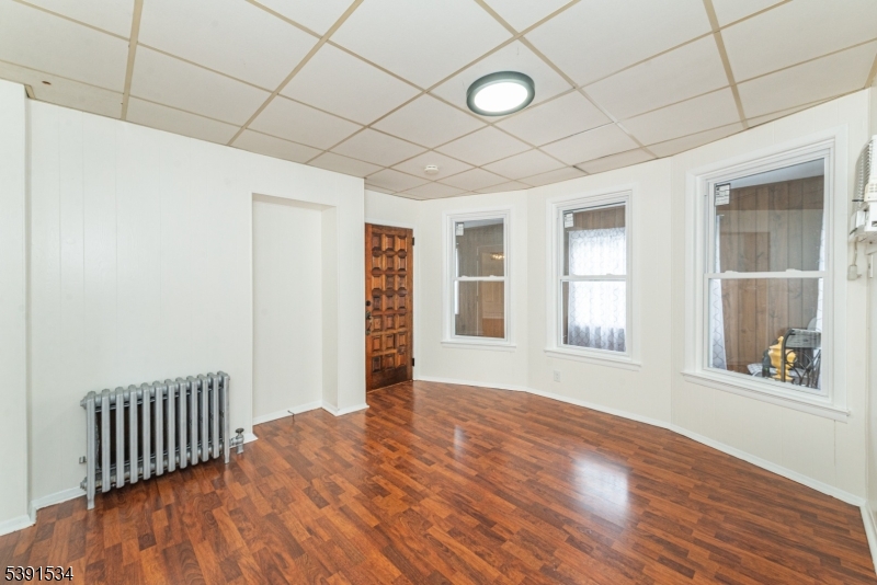 638 Clifton Avenue Clifton, NJ 07011 - Photo 10 of 21 an empty room with wooden floor and windows