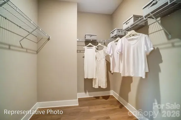a view of walk in closet with clothes and shoes
