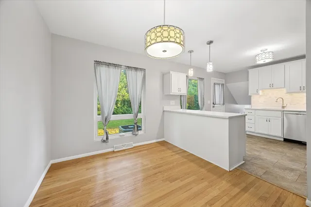 a view of a kitchen with wooden floor and window