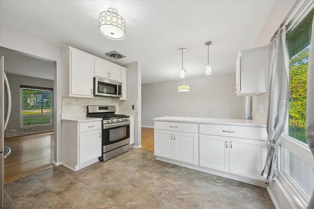 a kitchen with white cabinets and stainless steel appliances