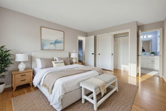 a bedroom with a bed and wooden floor