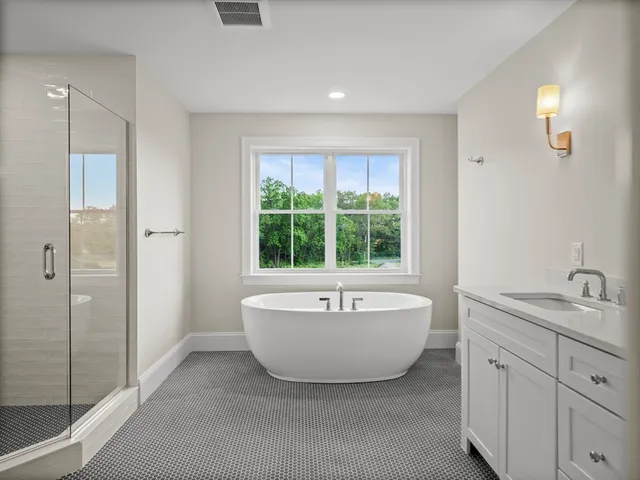 a spacious bathroom with a bathtub sink and mirror