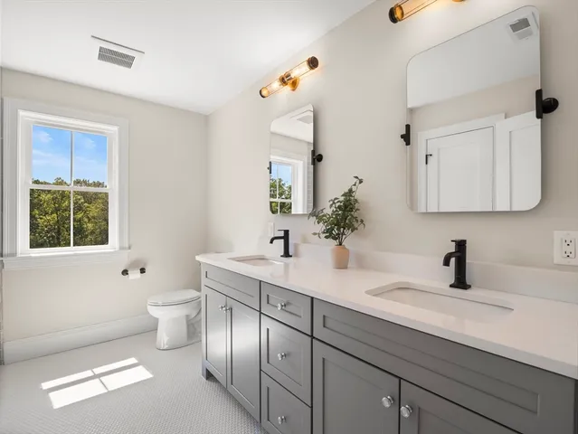 a bathroom with a sink a toilet and mirror