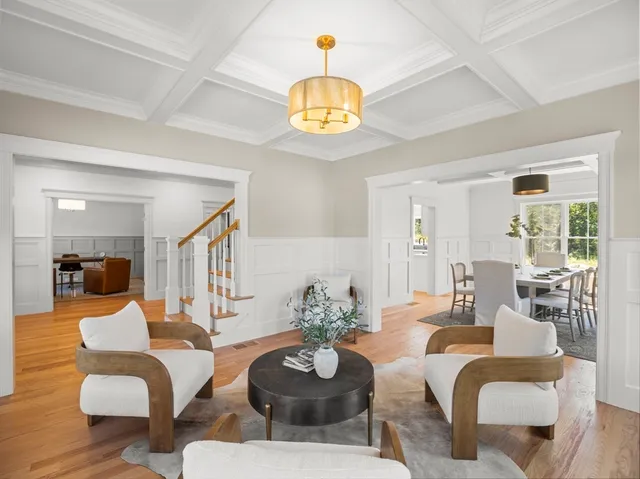 a living room with furniture a chandelier and a dining table